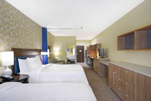 迪索托Home2 Suites By Hilton Dallas Desoto的酒店客房设有两张床和电视。