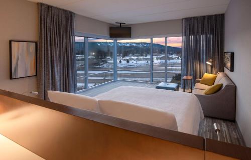 沃索Hilton Garden Inn Wausau, WI的一间卧室设有一张大床和一个大窗户