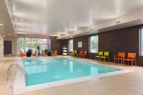奥尔巴尼奥尔巴尼机场/沃尔夫路希尔顿欣庭套房酒店的游泳池位于酒店客房内,配有桌椅