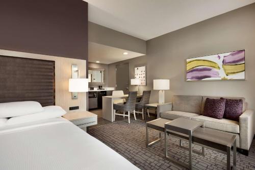 夏洛特夏洛特上城希尔顿合博套房酒店的酒店客房设有床和客厅。