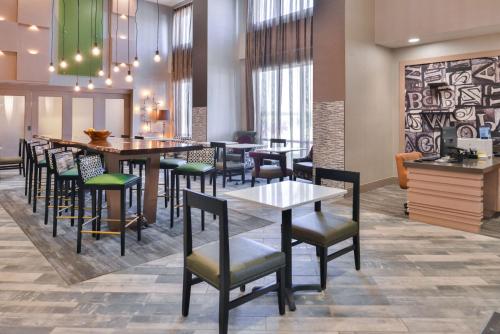 阿尔图纳阿尔图纳 - 得梅因希尔顿汉普顿酒店的餐厅设有酒吧,配有桌椅