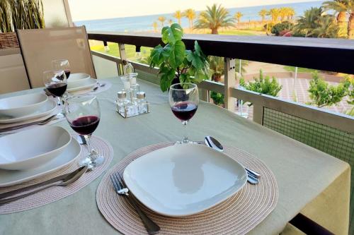 拉皮内达Arrecife Beach的阳台上的桌子上放着两杯红葡萄酒