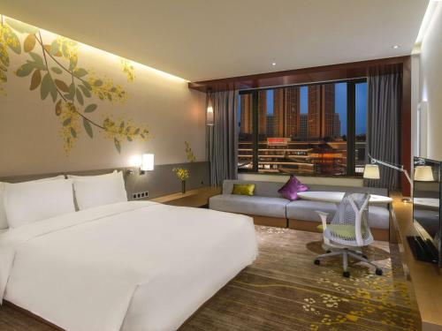 佛山佛山希尔顿花园酒店的酒店客房设有一张大床和一张沙发。
