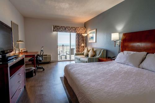奇蒂豪克奥特班克斯/奇提霍克希尔顿花园酒店的酒店客房配有一张床、一张书桌和一台电视。