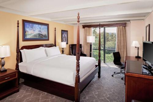 莫尔文The Desmond Hotel Malvern, a DoubleTree by Hilton的一间卧室配有一张床、一张书桌和一台电视