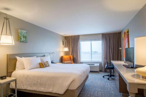 萨利纳Hilton Garden Inn Salina的酒店客房配有一张床、一张书桌和一台电视。