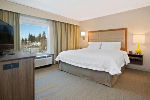 伍丁维尔汉普顿酒店及套房 - 华盛顿西雅图伍丁维尔的酒店客房,配有床和电视
