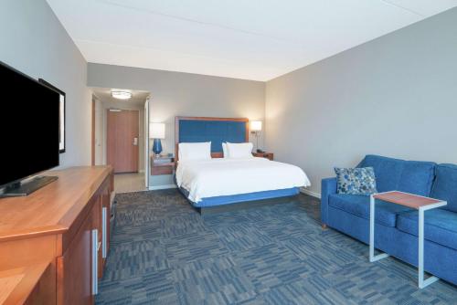 纽堡纽约纽堡斯图尔特机场汉普顿酒店的酒店客房,配有床和蓝色的沙发