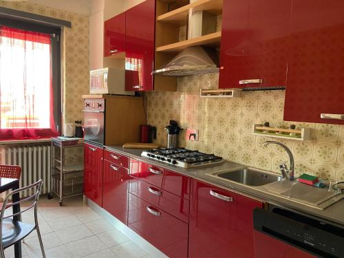 德鲁恩托Guest House MICINI的一间带红色橱柜和水槽的厨房