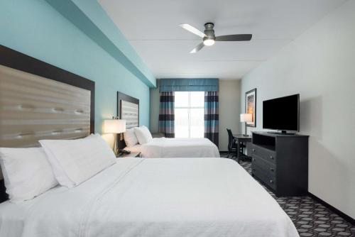 费耶特维尔Homewood Suites By Hilton Fayetteville的酒店客房设有两张床和一台平面电视。