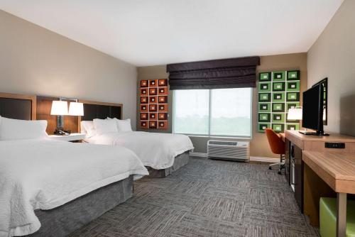墨尔本西墨尔本棕榈湾路汉普顿套房酒店 的酒店客房设有两张床和一台平面电视。