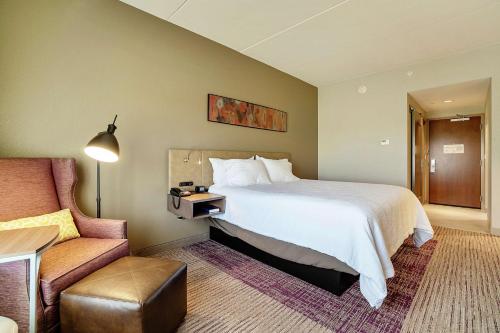 爱德蒙Hilton Garden Inn Edmond/Oklahoma City North的酒店客房带一张大床和一把椅子