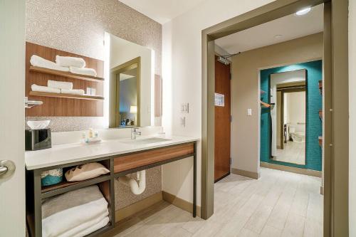 爱德蒙Hilton Garden Inn Edmond/Oklahoma City North的一间带水槽和大镜子的浴室
