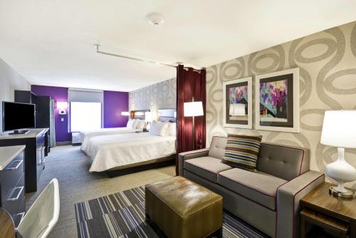 堪萨斯城KCI机场希尔顿惠庭酒店 的酒店客房,配有床和沙发