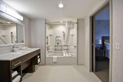 哥伦布Home2 Suites By Hilton Columbus Airport East Broad的带浴缸和盥洗盆的大浴室