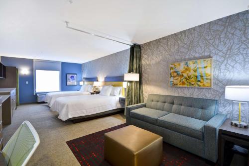 哥伦布Home2 Suites By Hilton Columbus Airport East Broad的酒店客房,配有床和沙发