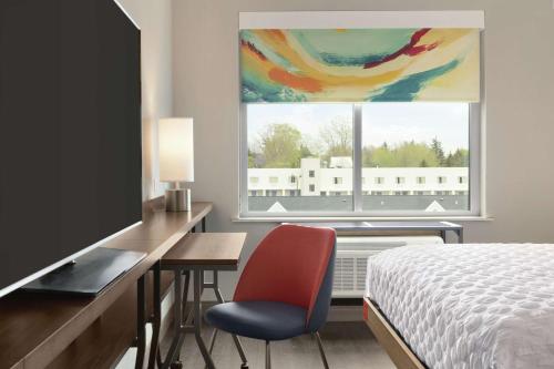 威廉斯维尔布法罗机场伊克诺旅店的一间卧室配有一张床和一张书桌及电视