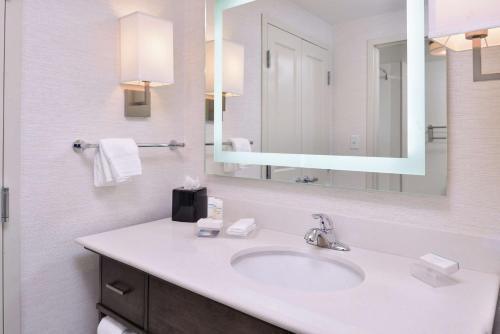 德梅因Homewood Suites Des Moines Airport的一间带水槽和镜子的浴室