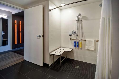 盐湖城盐湖城机场希尔顿Tru酒店的带淋浴的浴室和长凳