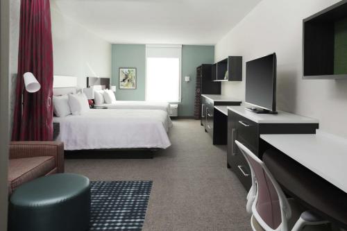 路易斯威尔Home2 Suites By Hilton Louisville Airport Expo Center的酒店客房,配有床和电视
