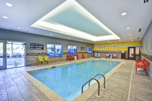 萨姆特Tru By Hilton Sumter的酒店大堂的游泳池,配有桌椅