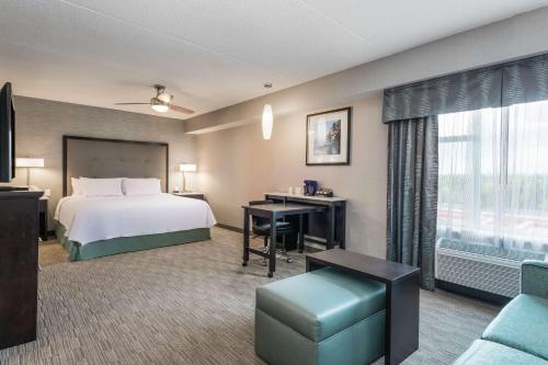渥太华Homewood Suites By Hilton Ottawa Airport的配有一张床和一张书桌的酒店客房
