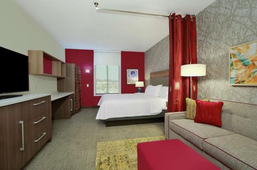 莫比尔Home2 Suites by Hilton Mobile I-65 Government Boulevard的酒店客房,配有床和沙发