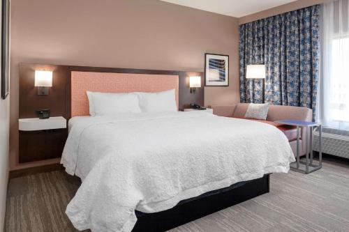 StanleyHampton Inn & Suites Overland Park South的酒店客房带一张大床和一把椅子