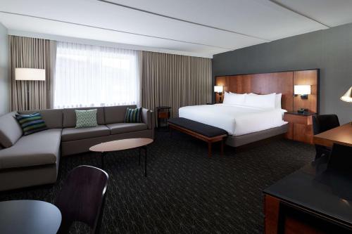 多瓦尔蒙特利尔机场希尔顿逸林酒店 的酒店客房,配有床和沙发