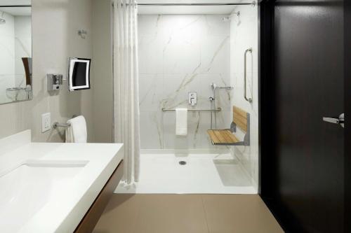 多瓦尔蒙特利尔机场希尔顿逸林酒店 的带淋浴和盥洗盆的白色浴室
