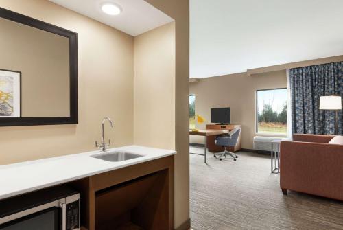 StanleyHampton Inn & Suites Overland Park South的一间带水槽的厨房和一间带沙发的客厅