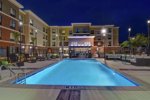 萨凡纳Homewood Suites By Hilton Savannah Airport的夜间在酒店前的游泳池