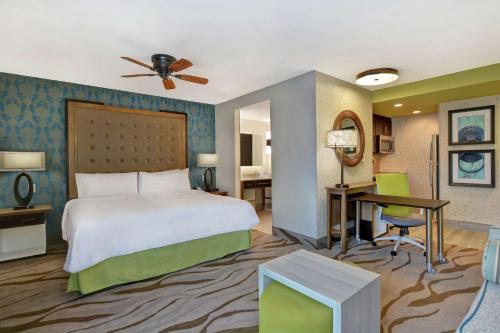 萨凡纳Homewood Suites By Hilton Savannah Airport的配有一张床和一张书桌的酒店客房
