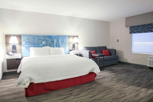 劳雷尔山Hampton Inn & Suites Mount Laurel/Moorestown的酒店客房设有一张大床和一张沙发。