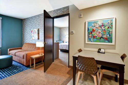 维克多维尔Home2 Suites by Hilton Victorville的客厅配有桌子和沙发