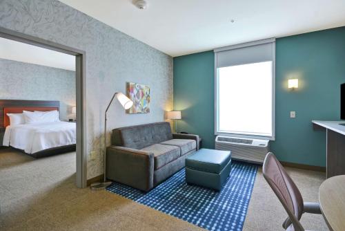 普利茅斯Home2 Suites By Hilton Plymouth Minneapolis的酒店客房设有一张沙发和一张床