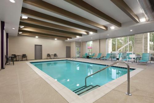 哥伦比亚Home2 Suites By Hilton Columbia Harbison的一个带蓝色桌椅的大型游泳池