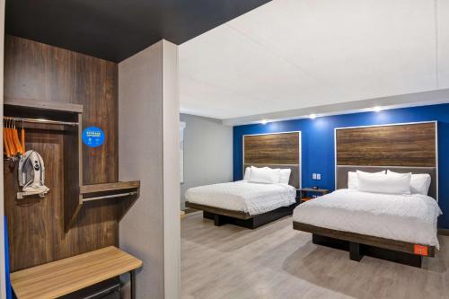 利物浦锡拉丘兹北机场区希尔顿Tru酒店的酒店客房,设有两张床和蓝色的墙壁
