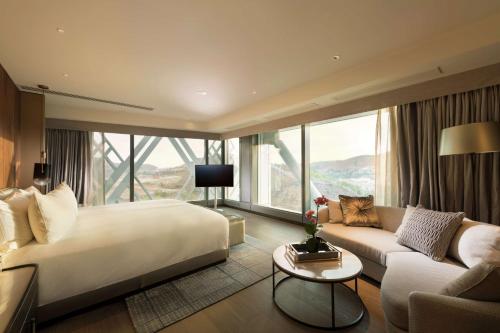 莫尔兹比港Hilton Port Moresby Hotel & Residences的酒店客房设有一张大床和一张沙发。