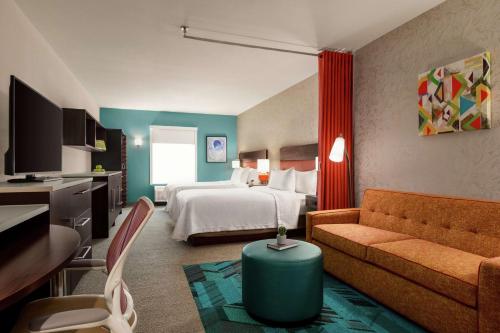 圣安东尼奥Home2 Suites By Hilton San Antonio North Stone Oak的酒店客房,配有床和沙发