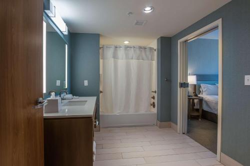 贝尔维尤Home2 Suites By Hilton Nashville Bellevue的一间带水槽和淋浴的浴室以及一张床