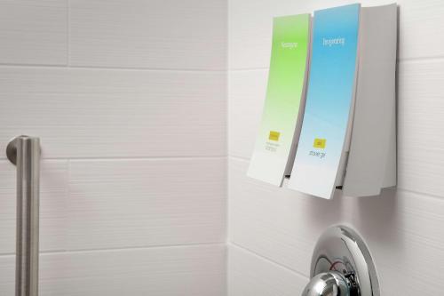 莱克兰Home2 Suites By Hilton Lakeland的浴室设有淋浴,墙上有两个标志