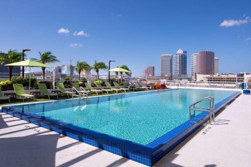 坦帕Hampton Inn Tampa Downtown Channel District的一个带椅子的大型游泳池,享有城市天际线