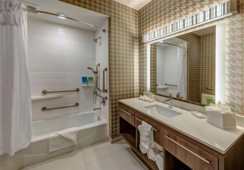 里诺Home2 Suites By Hilton Reno的带浴缸、水槽和镜子的浴室