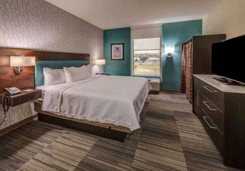 里诺Home2 Suites By Hilton Reno的配有一张床和一台平面电视的酒店客房