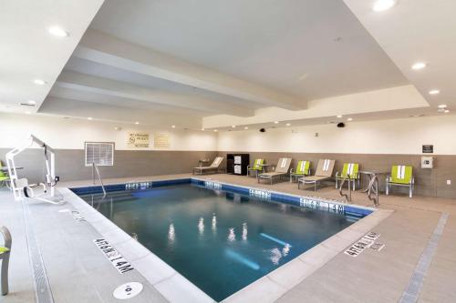 达拉斯Hampton Inn & Suites Dallas East的一个带椅子和篮球场的酒店游泳池