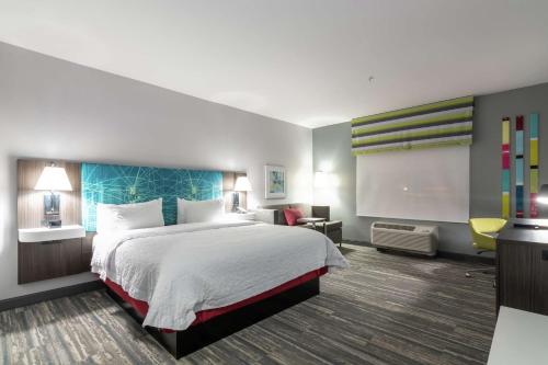 达拉斯Hampton Inn & Suites Dallas East的酒店客房设有一张大床和一台电视机。