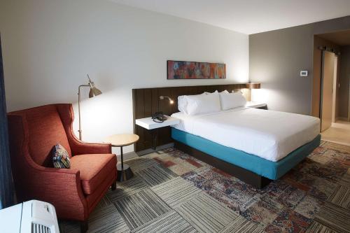 伊丽莎白镇Hilton Garden Inn Elizabethtown的配有一张床和一把椅子的酒店客房