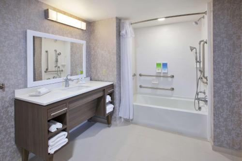 霍兰Home2 Suites By Hilton Holland的一间带水槽、浴缸和淋浴的浴室