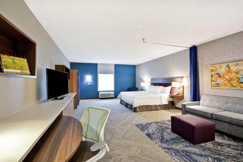 普莱诺Home2 Suites Plano Legacy West的酒店客房,配有床和沙发
